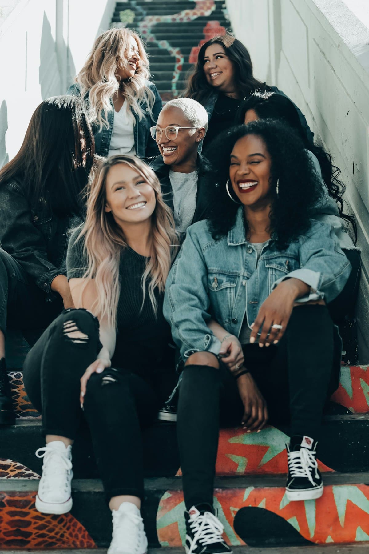 A group of women sitting together on steps, laughing